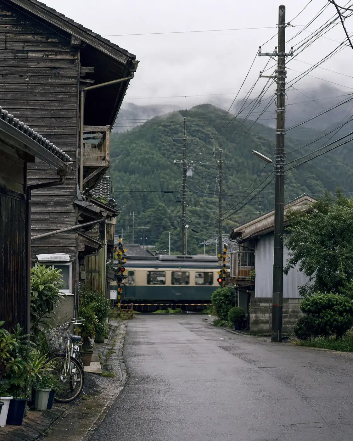 Train régional traversant une petite ville japonaise entourée de montagnes